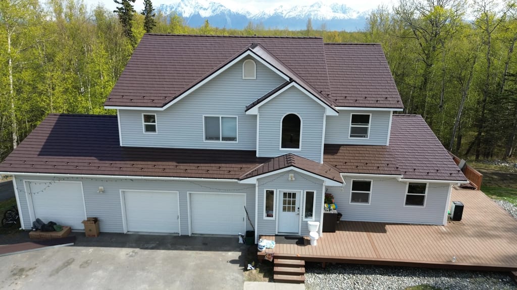 A modern style home with a brown metal roof and white siding