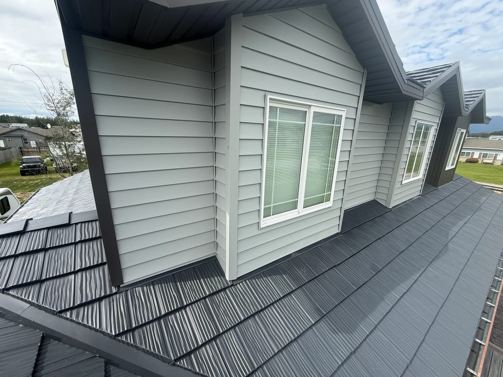 A modern metal roof with a grey finish on a single-family home in a suburban area.