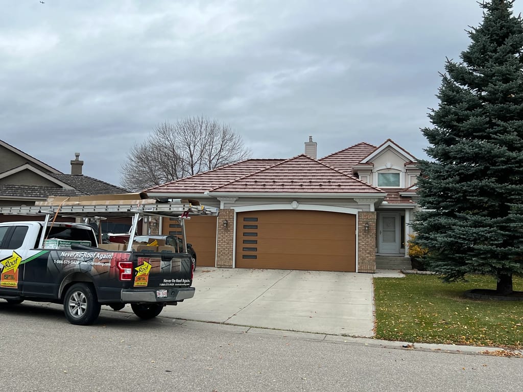 Aged Copper Interlock Shake aluminum roof on a tan ranch home with a metal roof in a residential, Calgary, Alberta