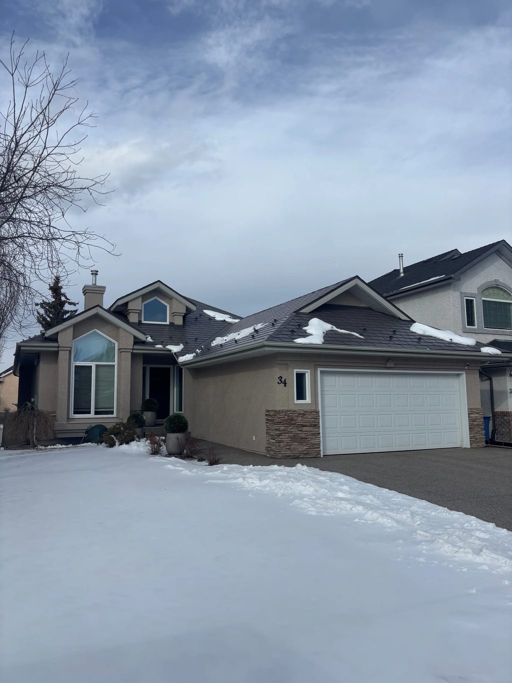 Weathered Interlock Slate aluminum roof on a beige one-storey home with a garage in a suburban, Calgary, Alberta