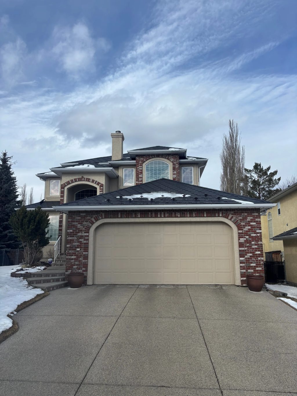 Black Interlock Slate aluminum roof on a two-storey home with a metal roof and brick accents in a, Calgary, Alberta