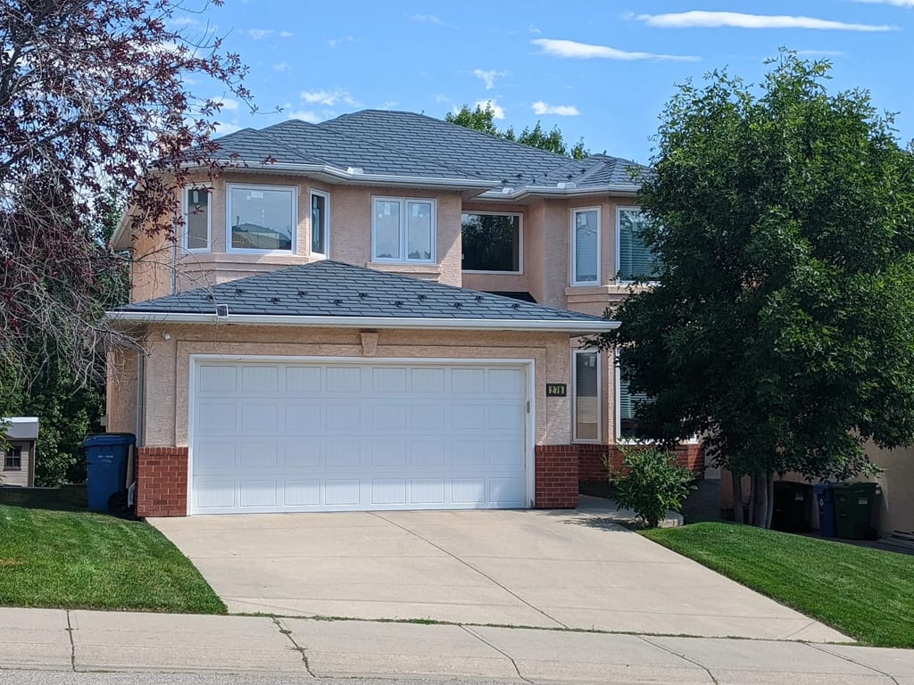 Deep Charcoal Interlock Slate aluminum roof on a two-storey home with a garage and a tree in front, Calgary, Alberta