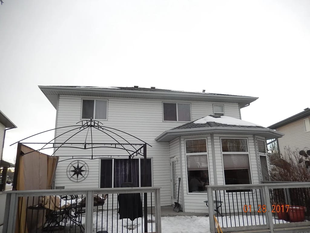 Deep Charcoal Interlock Slate aluminum roof on a white two-storey home with a metal roof in rural Alberta, Fort Saskatchewan, Alberta