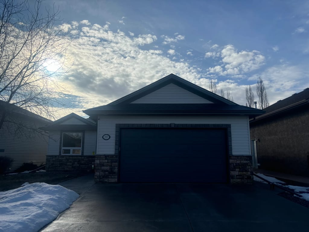Deep Charcoal Interlock Slate aluminum roof on a red brick home with one storey and a brown garage door, Red Deer, Alberta