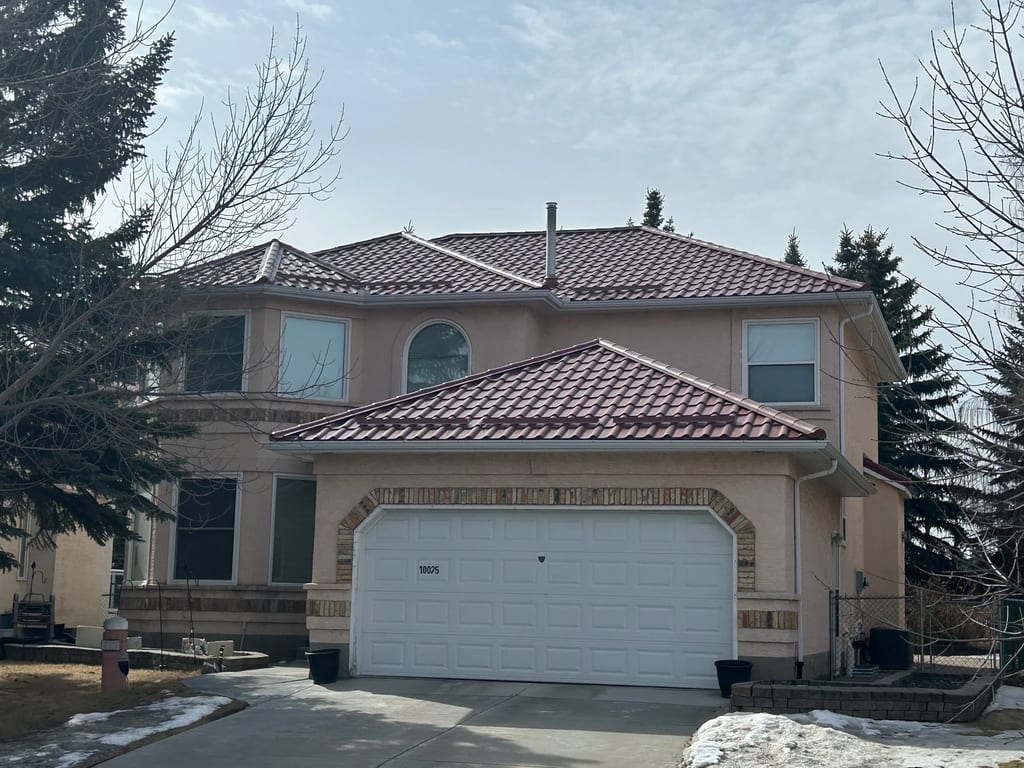 Tile Red Interlock Tile aluminum roof on a tan house with a tile red metal roof in Calgary, Alberta, Calgary, Alberta