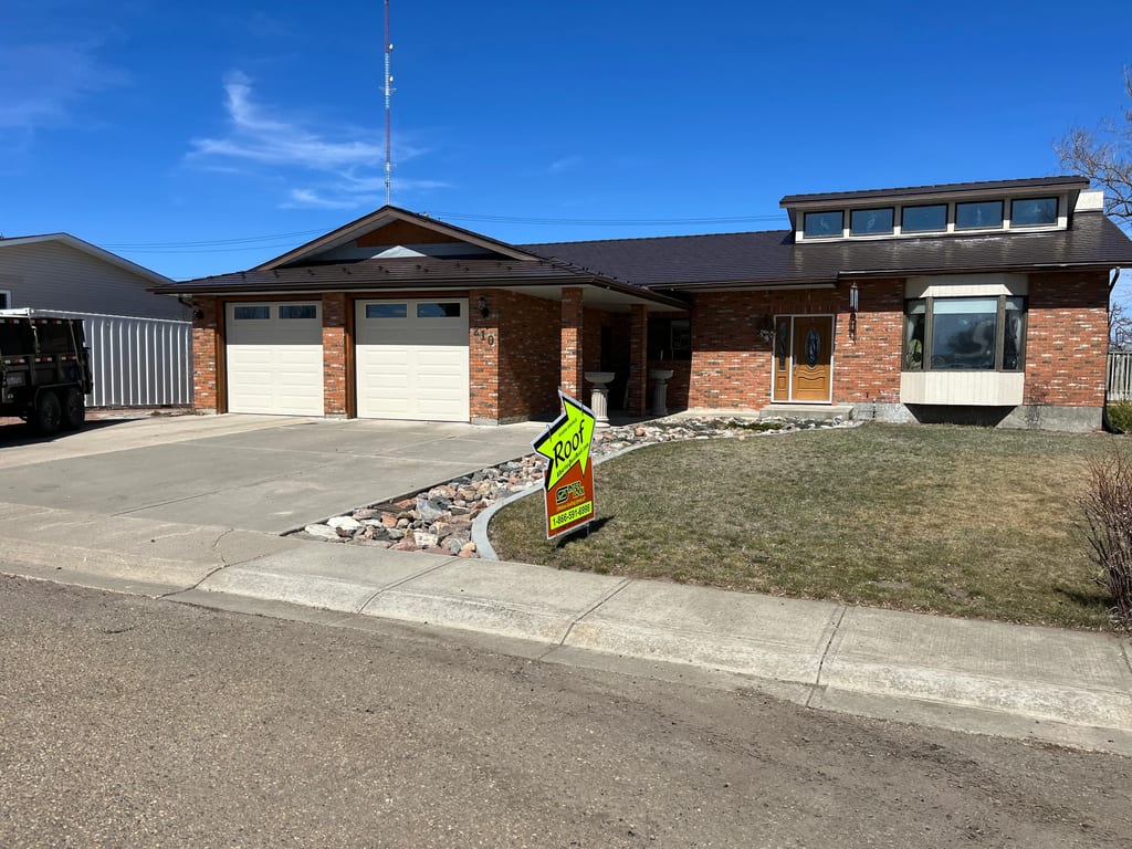 Colonial Brown Interlock Slate aluminum roof on a brown single-storey home with dormers in a rural setting, Oyen, Alberta