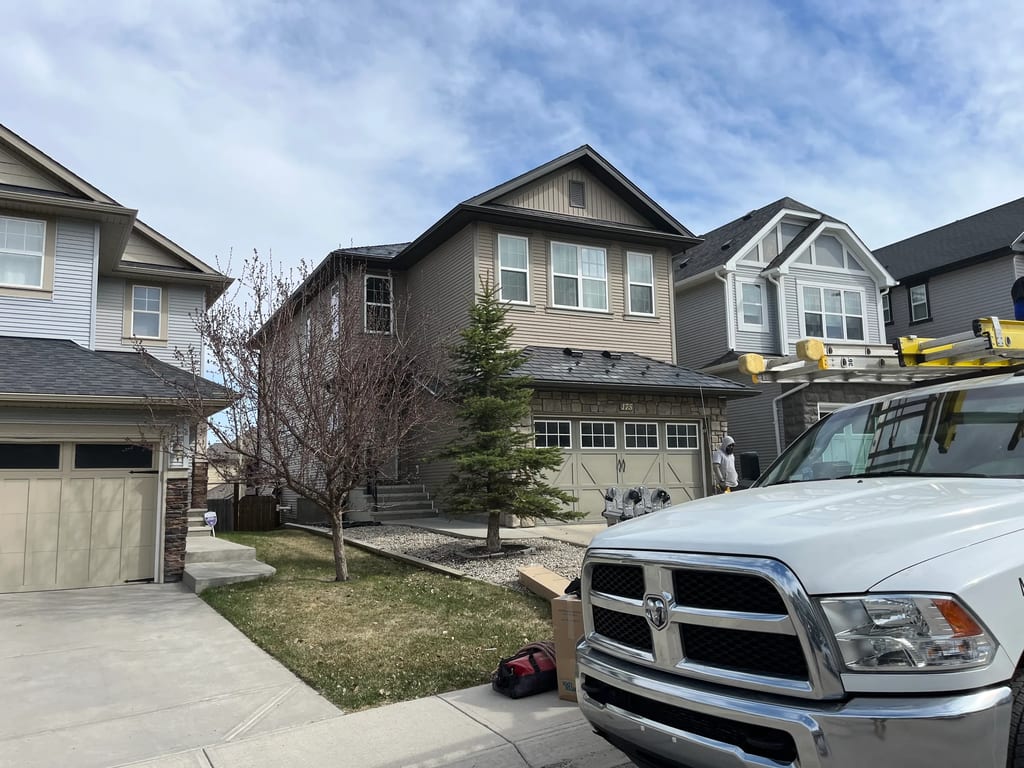 Deep Charcoal Interlock Slate aluminum roof on a tan two-storey home with a metal roof among urban, Calgary, Alberta
