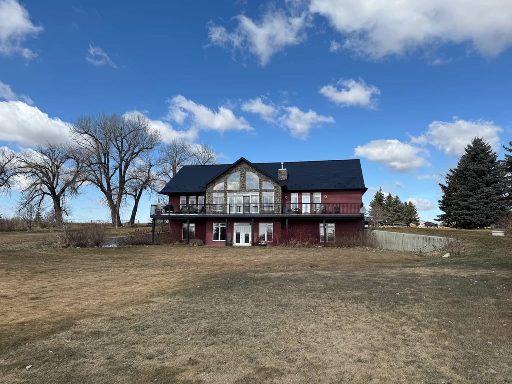 Black Interlock Slate aluminum roof on a red two-storey home with dormers in a rural setting, Gem, Alberta