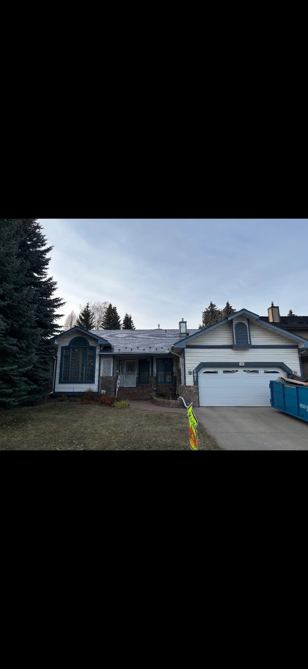 Musket Grey Interlock Slate aluminum roof on a white one-storey home with a metal roof in a suburban, Calgary, Alberta