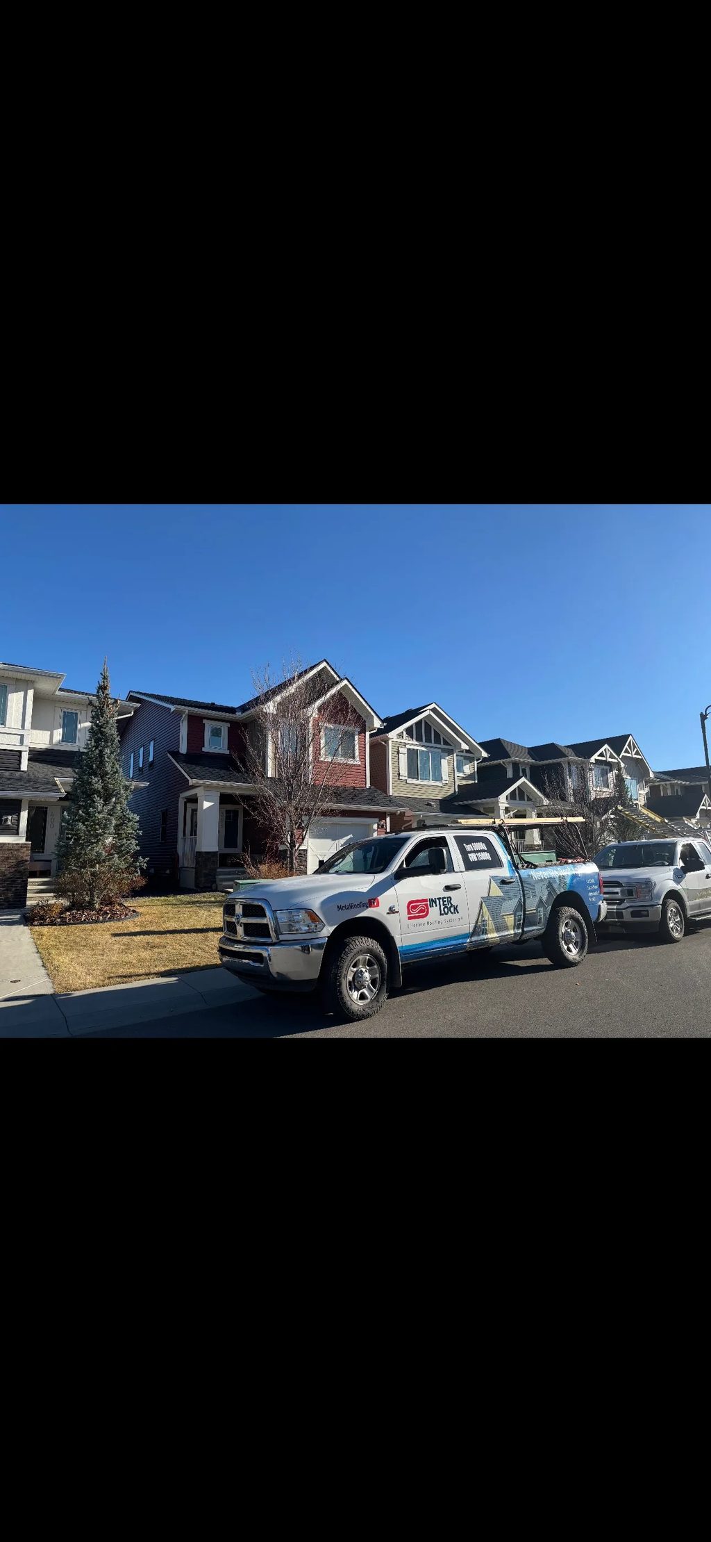 Black Interlock Slate aluminum roof being installed on the home, replacing an asphalt shingle roof being torn off, Airdrie, Alberta