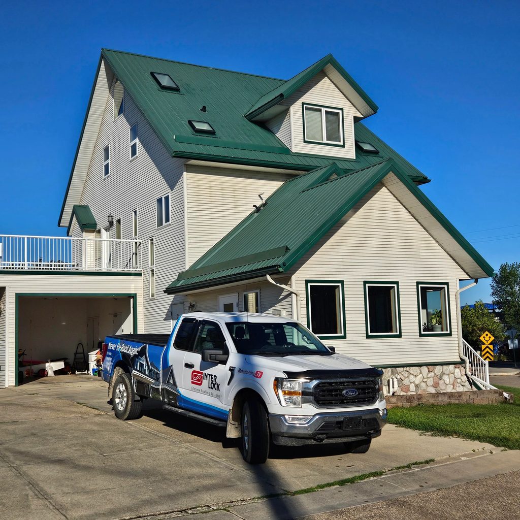Hunter Green Interlock Cedar Shingle aluminum roof on a white cottage with a green metal roof on a lakeside lot, Sylvan Lake, Alberta