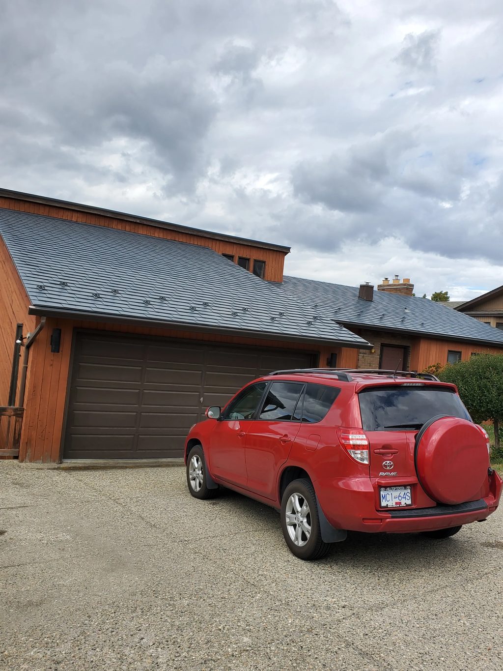 Slate Blue Interlock Slate aluminum roof on a red metal roof on a brown house in a mountain setting, Vernon, British Columbia