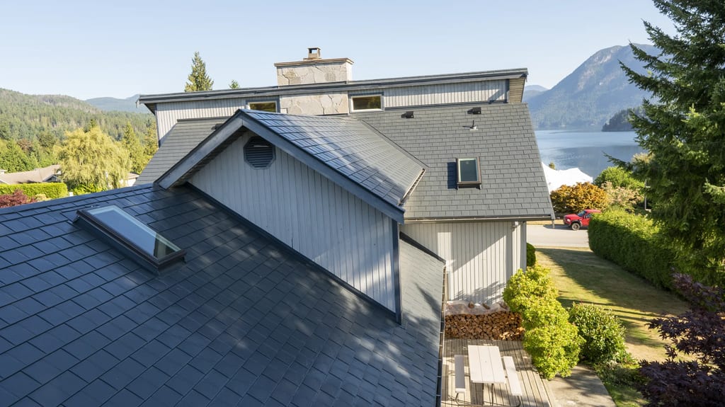 Deep Charcoal Interlock Slate aluminum roof on a grey home with a metal roof on a coastal mountain, Sechelt, British Columbia