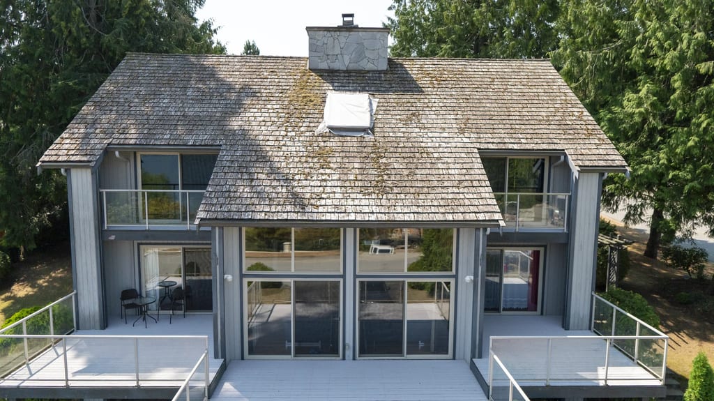 Before: a mossy wood shake roof on the home, Sechelt, British Columbia, ahead of a Deep Charcoal Interlock Slate aluminum roof
