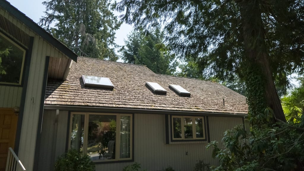 Before: a mossy wood shake roof on the home, Sechelt, British Columbia, ahead of a Deep Charcoal Interlock Slate aluminum roof
