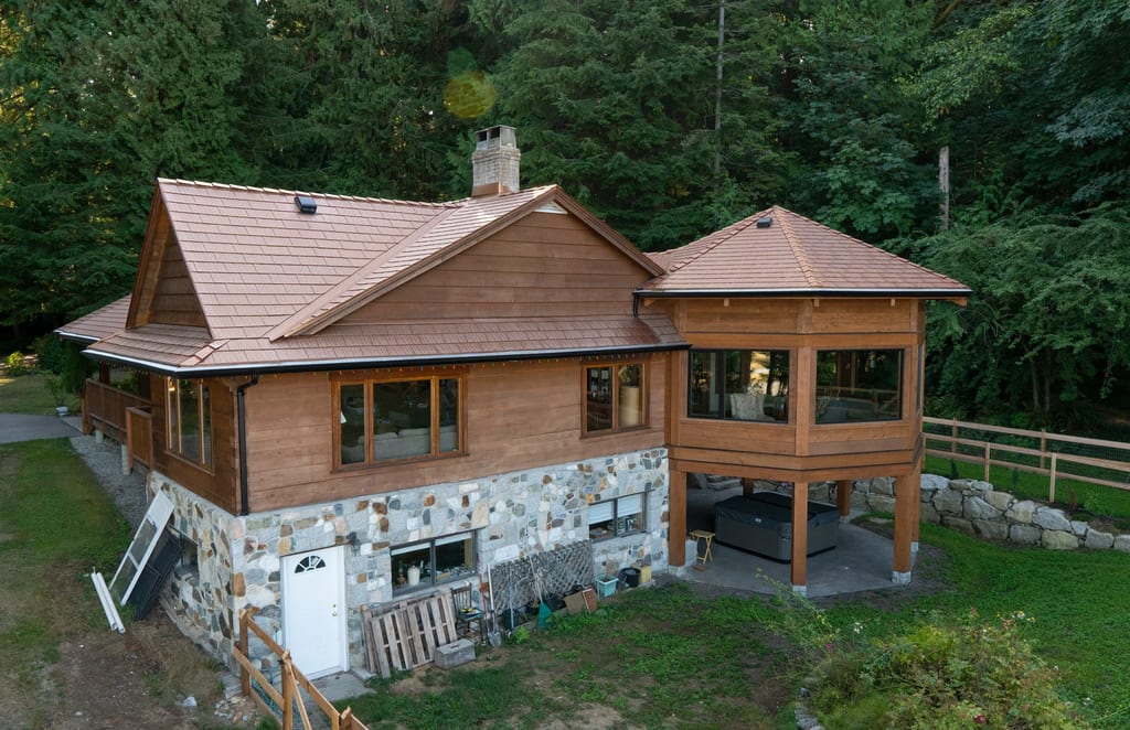Aged Copper Interlock Cedar Shingle aluminum roof on a home with a copper metal roof in a forested rural setting, Sechelt, British Columbia