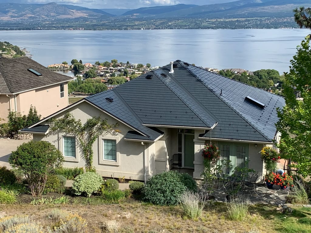 Deep Charcoal Interlock Slate aluminum roof on a beige single-family home with a slate metal roof and a, West Kelowna, British Columbia