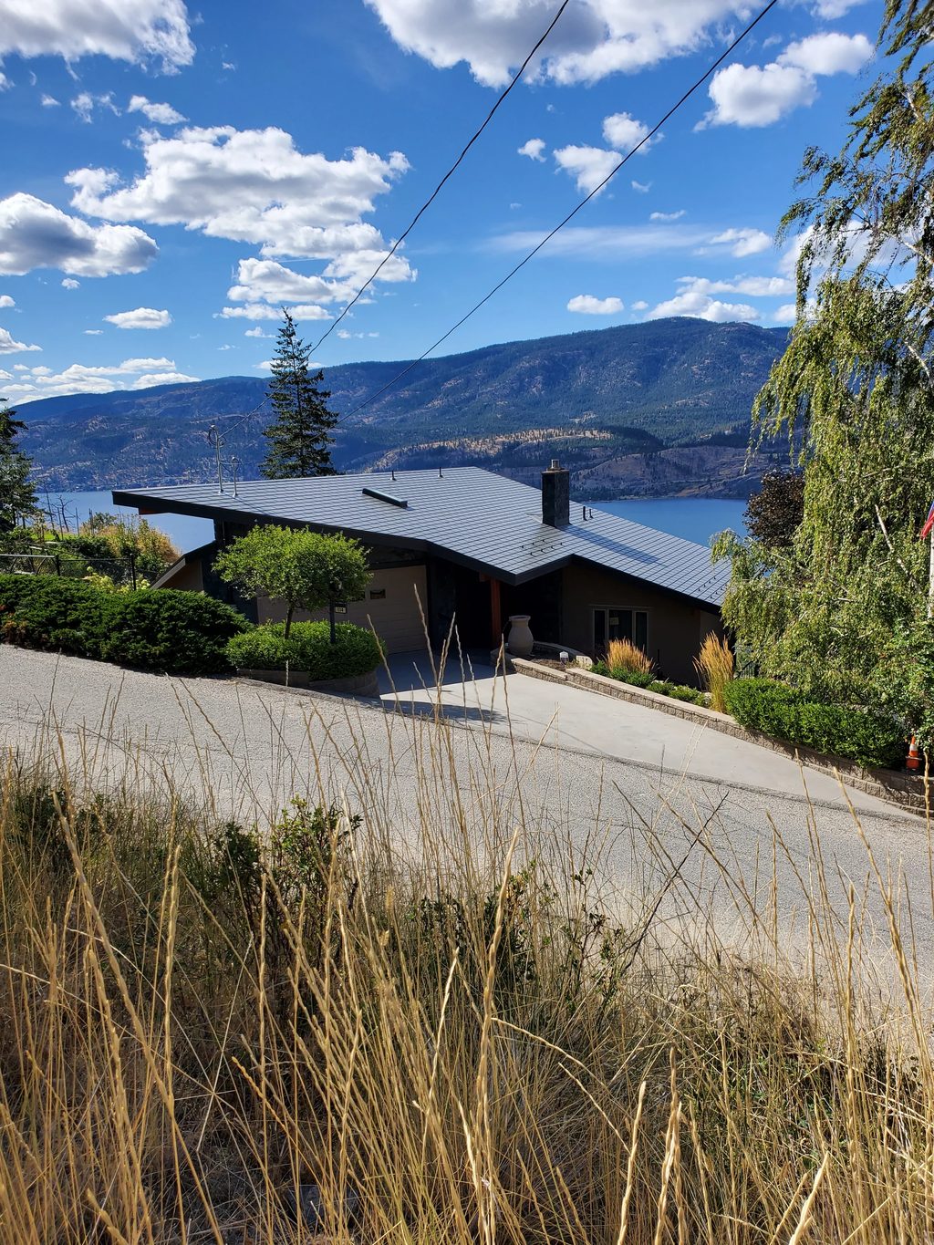 Deep Charcoal Interlock Slate aluminum roof on a Deep Charcoal metal roof on a brown home in a mountain, Kelowna, British Columbia