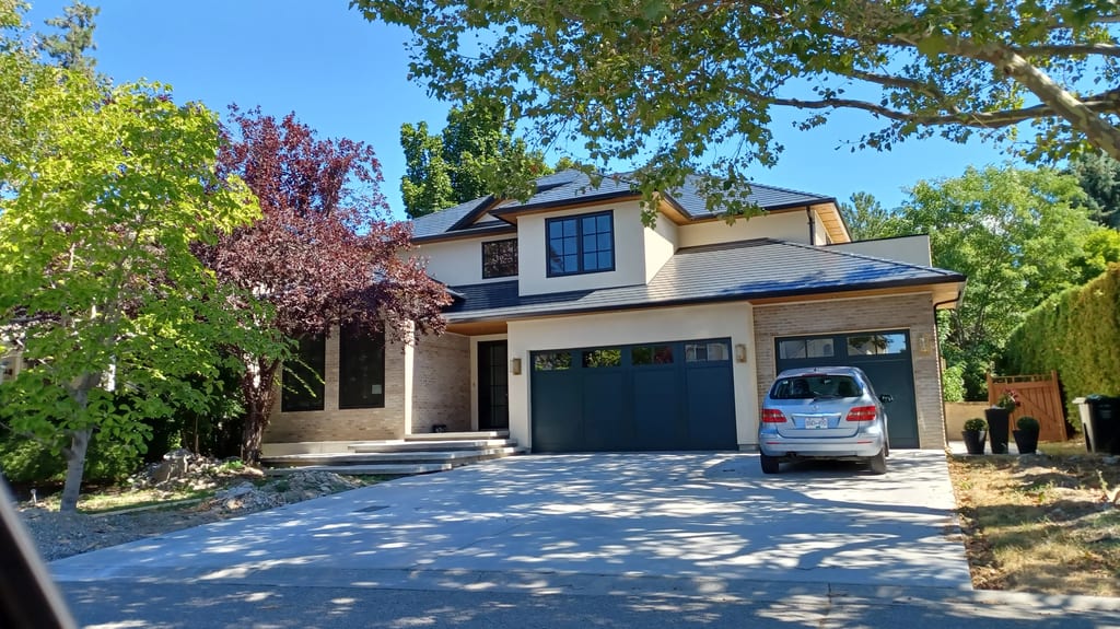 Black Interlock Slate aluminum roof on a modern home with a metal roof in a forested rural setting, Kelowna, British Columbia