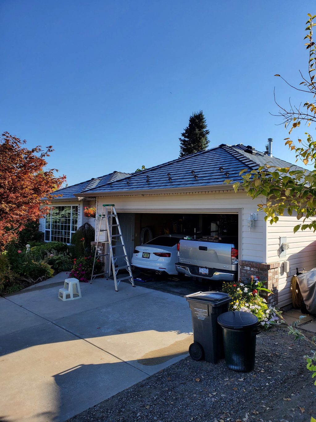 Deep Charcoal Interlock Slate aluminum roof on a white single-family home with a metal roof in a, West Kelowna, British Columbia