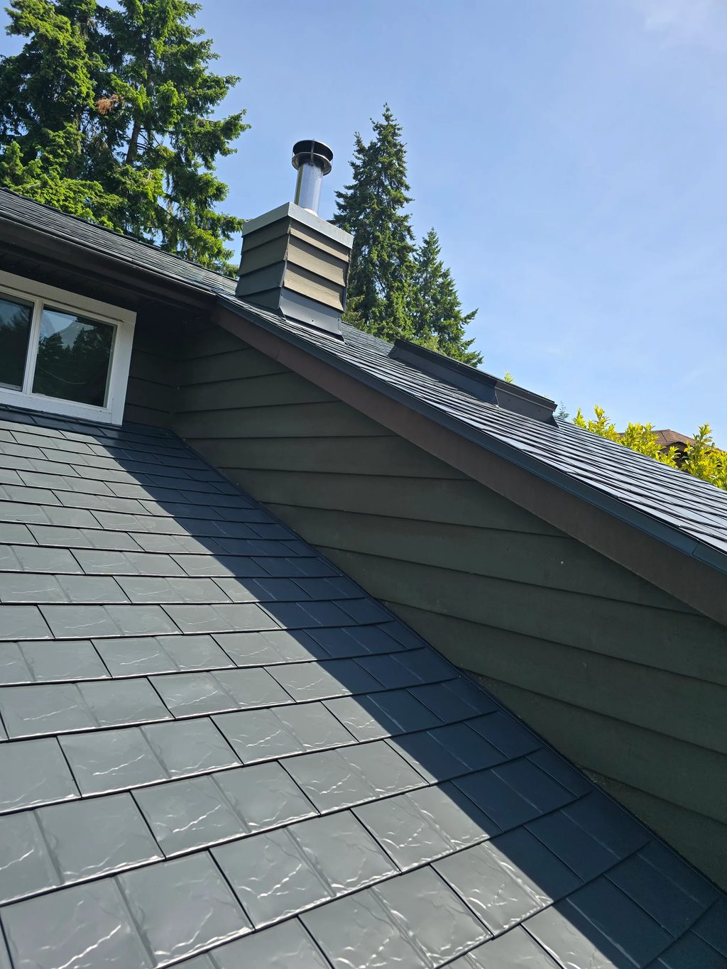 Deep Charcoal Interlock Slate aluminum roof on a two-storey home with dormers in a forested area, Sechelt, British Columbia