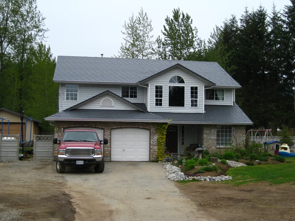 Charcoal Grey Interlock Slate aluminum roof on a colonial style home with a metal roof in a forested rural, Mission, British Columbia