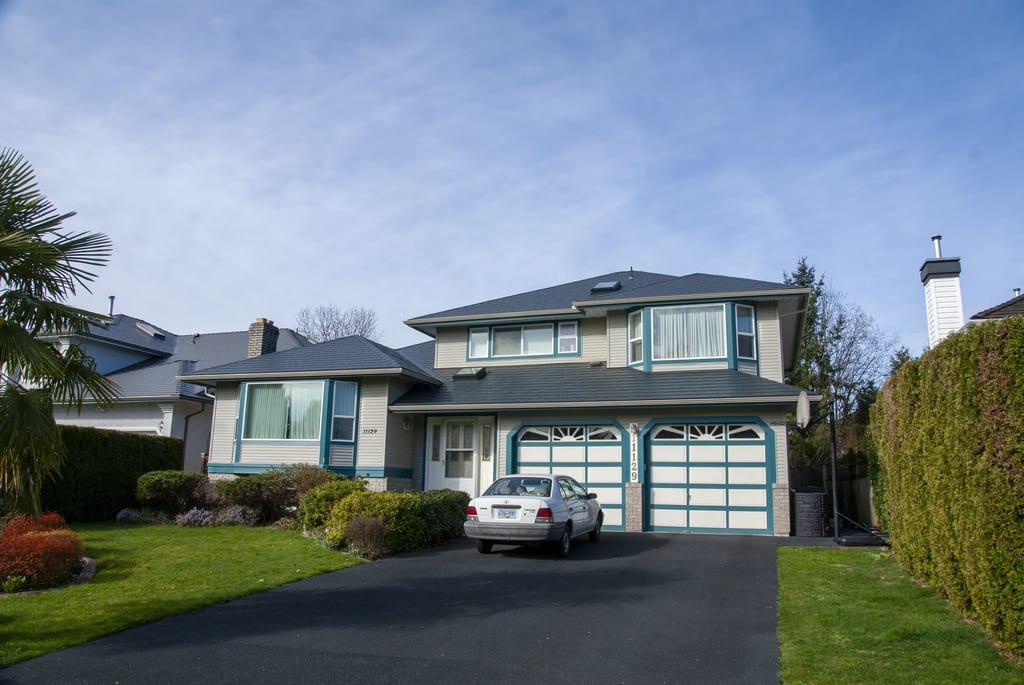 Deep Charcoal Interlock Slate aluminum roof on a two-storey home with blue trim and garage doors in a, Surrey, British Columbia