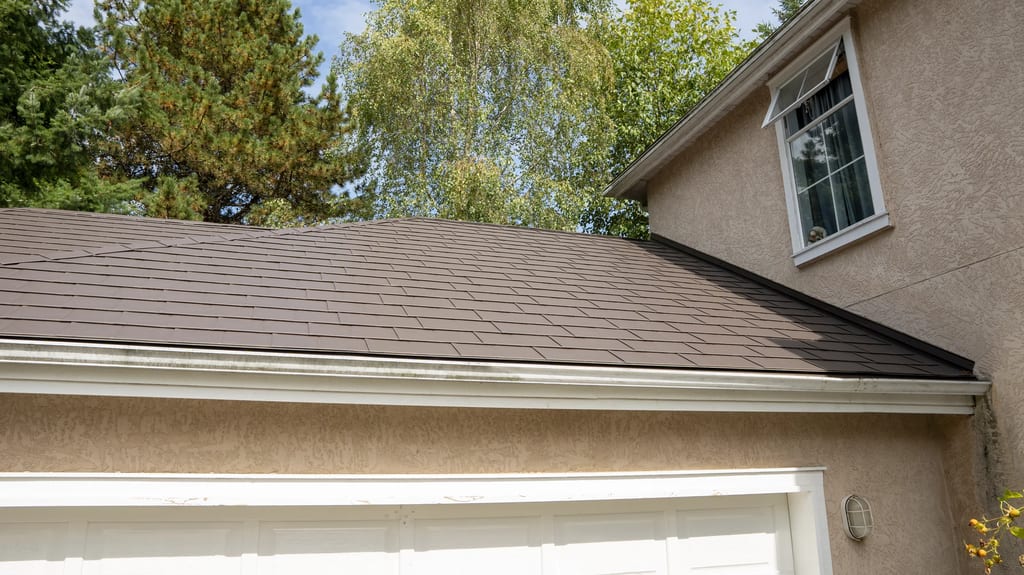 Tudor Brown Interlock Slate aluminum roof on a two-storey Tudor home with dormers in a suburban forest, Surrey, British Columbia