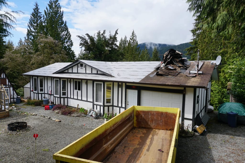 Deep Charcoal Interlock Slate aluminum roof being installed on the home, replacing a mossy asphalt shingle roof, Mission, British Columbia