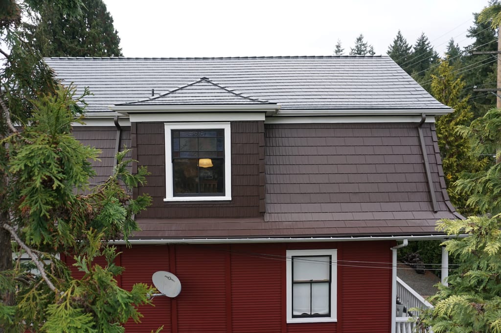 Colonial Brown Interlock Cedar Shingle aluminum roof on a brown colonial home with dormers in a forested area, New Westminster, British Columbia