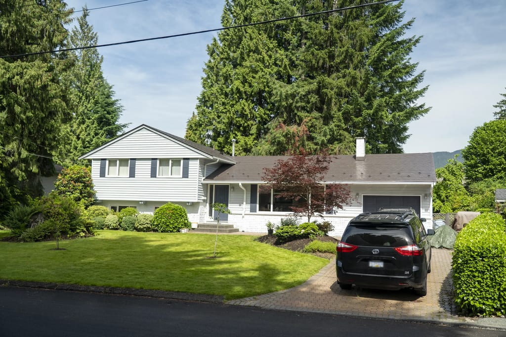 Tudor Brown Interlock Slate aluminum roof on a white Tudor home with dormers in a suburban mountain, North Vancouver, British Columbia