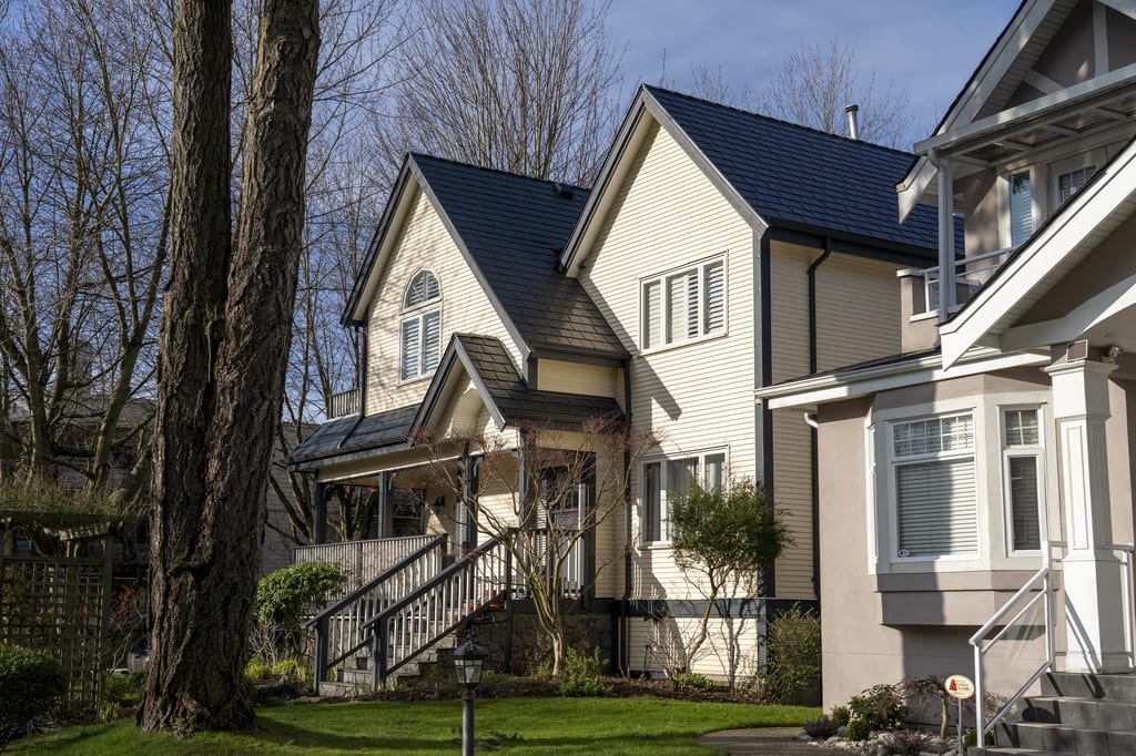 Deep Charcoal Interlock Slate aluminum roof on a two-storey home with beige siding and a deep charcoal, Vancouver, British Columbia