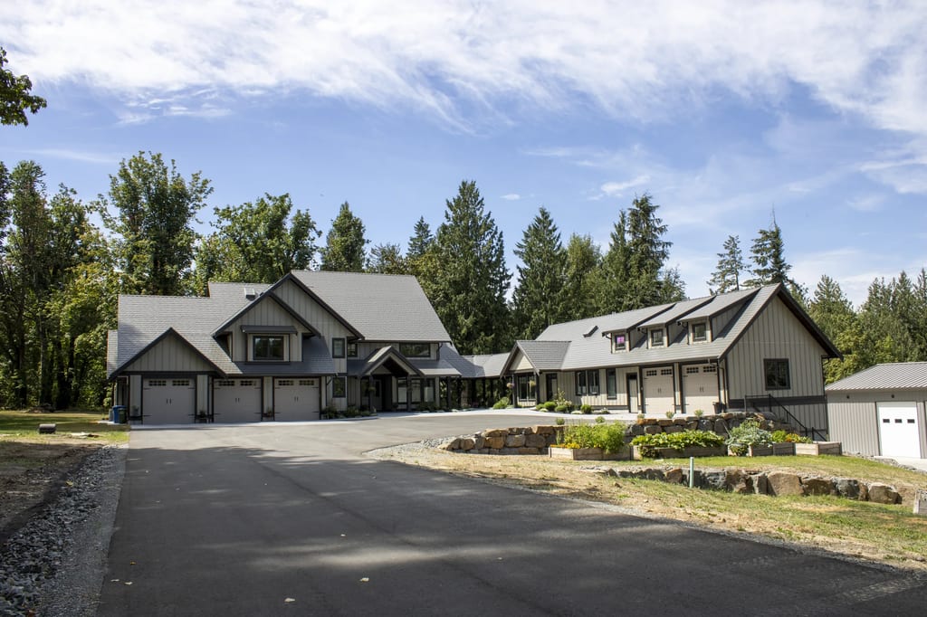 Musket Grey Interlock Slate aluminum roof on a grey modern home with dormers in a forested rural setting, Abbotsford, British Columbia