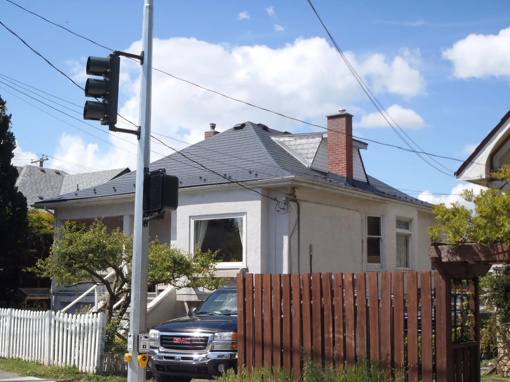 Deep Charcoal Interlock Slate aluminum roof on a white single-family home in a suburban setting, Victoria, British Columbia