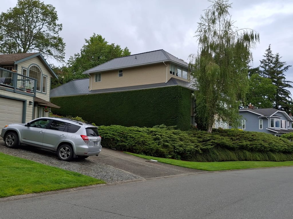 Deep Charcoal Interlock Slate aluminum roof on a single-family home with a metal roof in a suburban area, Duncan, British Columbia