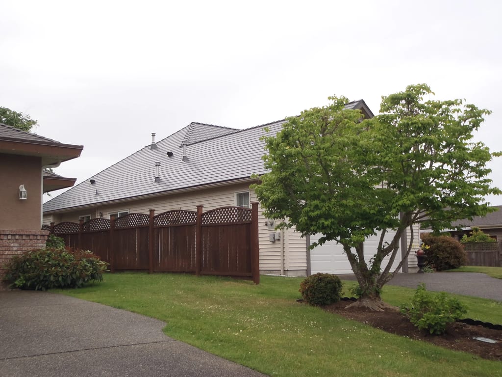 Deep Charcoal Interlock Slate aluminum roof on a white home with a metal roof in a suburban neighbourhood, Qualicum Beach, British Columbia