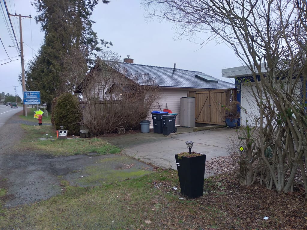 Black Interlock Slate aluminum roof on a white single-family home with a metal roof in a rural, Qualicum, British Columbia