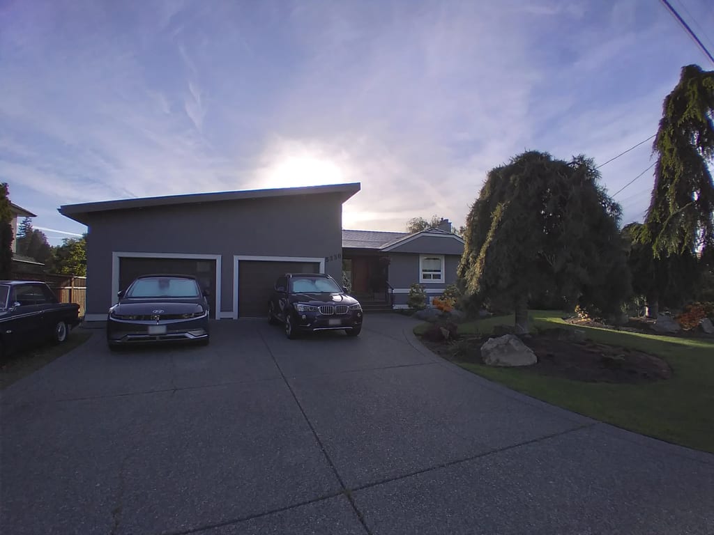 Deep Charcoal Interlock Slate aluminum roof on a grey house with a metal roof and a tree in the front yard, Victoria, British Columbia
