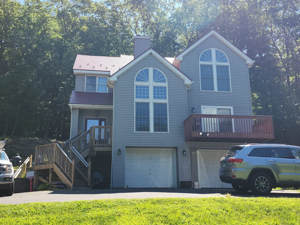 Tile Red Interlock Slate aluminum roof on a two-storey home with a grey metal roof and dormers among, Granby, Connecticut