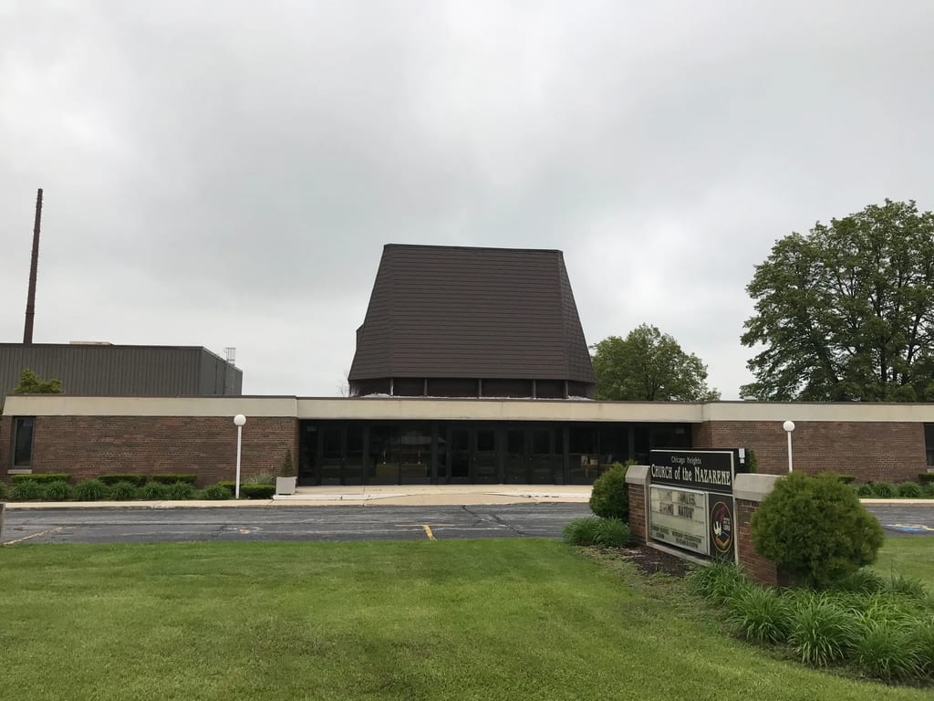 White Interlock IB Membrane aluminum roof on a red brick church with a brown roof in a suburban setting, Chicago Heights, Illinois
