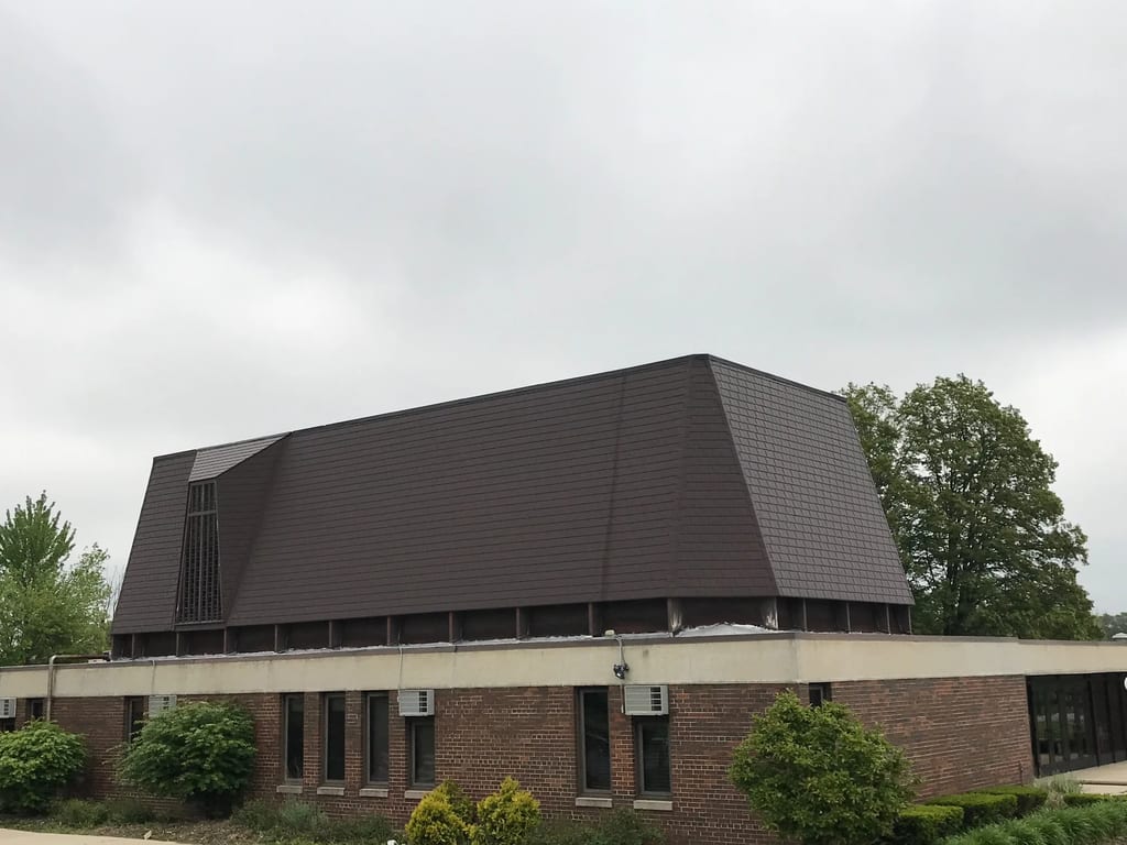 White Interlock IB Membrane aluminum roof on a brown single-storey home with dormers and shrubs in a, Chicago Heights, Illinois
