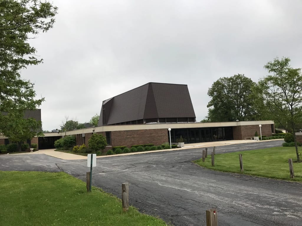 White Interlock IB Membrane aluminum roof on a brown single-storey home with a gable roof in an urban, Chicago Heights, Illinois
