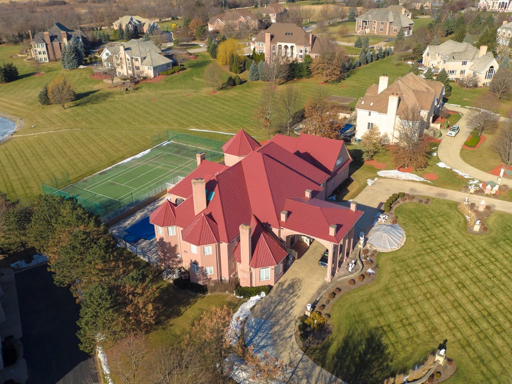 Tile Red Interlock Tile aluminum roof on a red two-storey colonial home with dormers in a suburban, South Barrington, Illinois