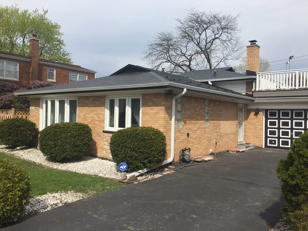 Black Interlock Slate aluminum roof on a tan brick home with a metal roof in a suburban, Skokie, Illinois