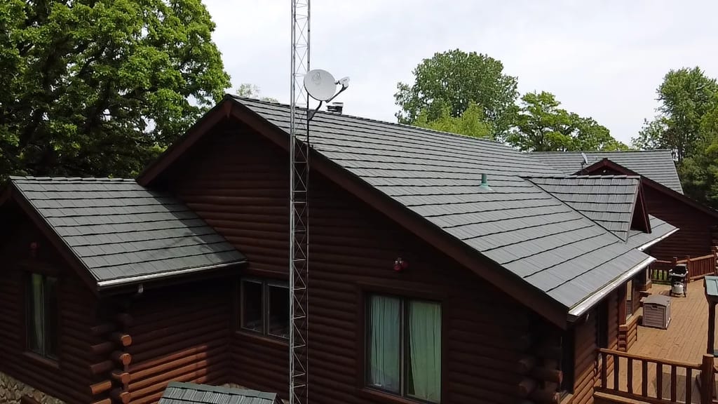 Hunter Green Interlock Shake aluminum roof on a brown log cabin among tall green trees, Harvard, Illinois