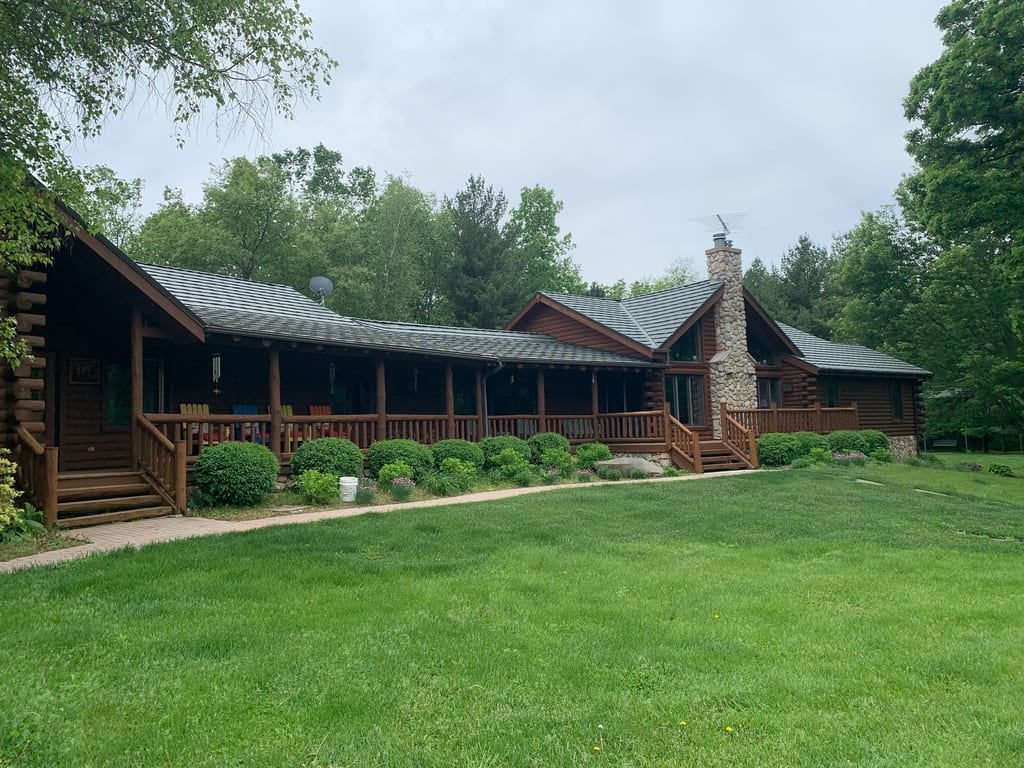 Hunter Green Interlock Shake aluminum roof on a brown ranch home with a green metal roof in a wooded area, Harvard, Illinois