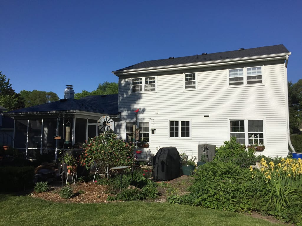 Black Interlock Slate aluminum roof on a white two-storey colonial home with dormers in a suburban, Batavia, Illinois