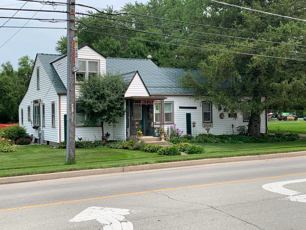 Hunter Green Interlock Slate aluminum roof on a white house with a metal roof and Hunter Green shingles, Braidwood, Illinois