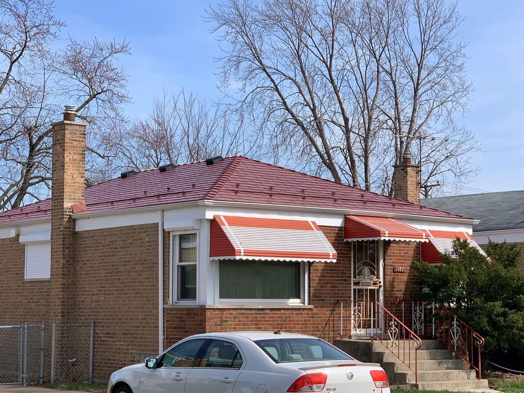 Tile Red Interlock Slate aluminum roof on a red roofed brick house with a white car in front, Calumet Park, Illinois