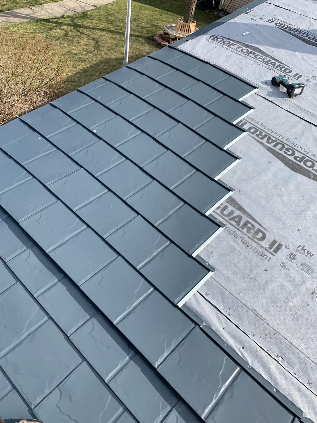 Deep Charcoal Interlock Slate aluminum roof being installed on a two-storey home with dormers in a suburban setting, Waukegan, Illinois